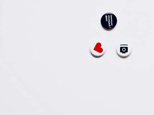 australia three white and black button pins on white surface red